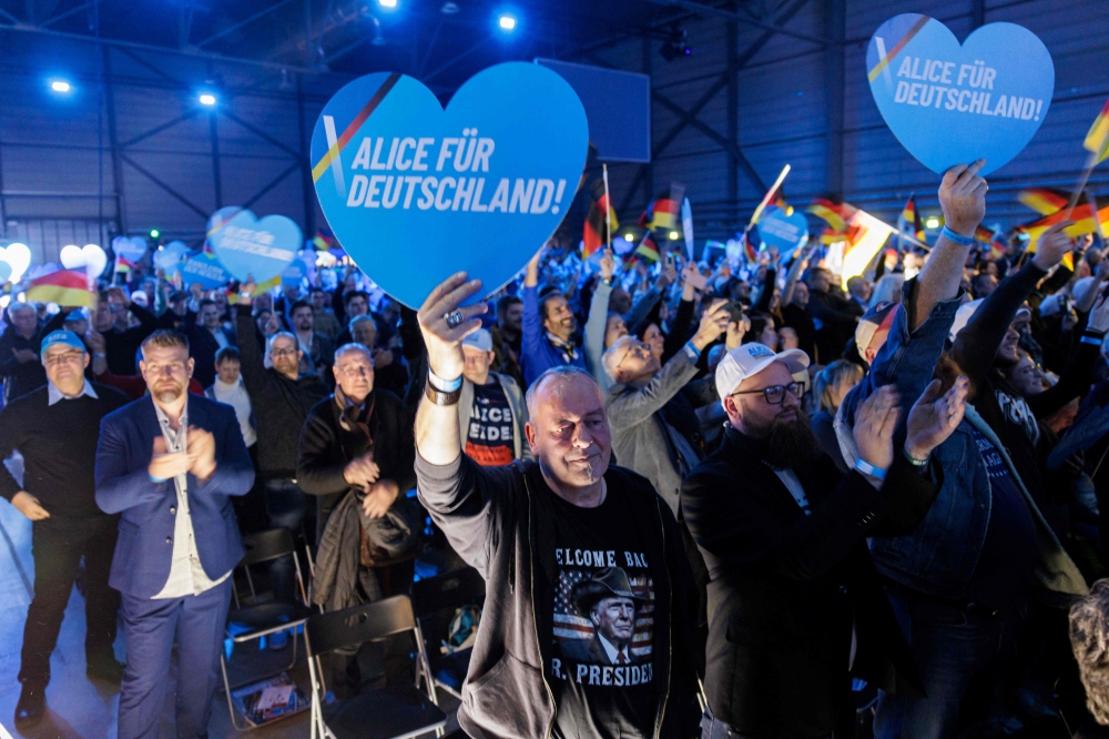 A supporter wearing a t-shirt in favor of US President Donald Trump holds up a heart-shaped placard to cheer for Alice Weidel, co-leader of German far-right Alternative for Germany (AfD) party, as she addresses an election campaign rally in Halle. — Pic by AFP