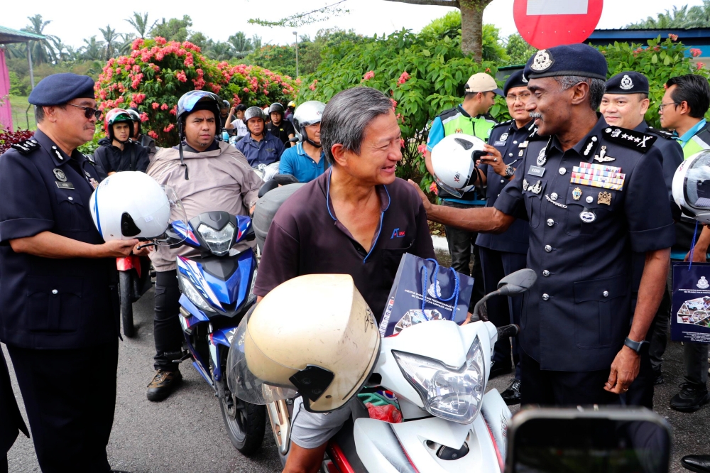 Johor police chief Datuk M. Kumar speaks to a motorcyclist during the Johor police’s Road Safety Advocacy Programme in collaboration with the Johor Social Security Organisation (Perkeso) for Op Selamat in conjunction with the Chinese New Year celebration at the northbound Kempas Toll Plaza in Johor Baru, January 27, 2025. — Bernama pic 