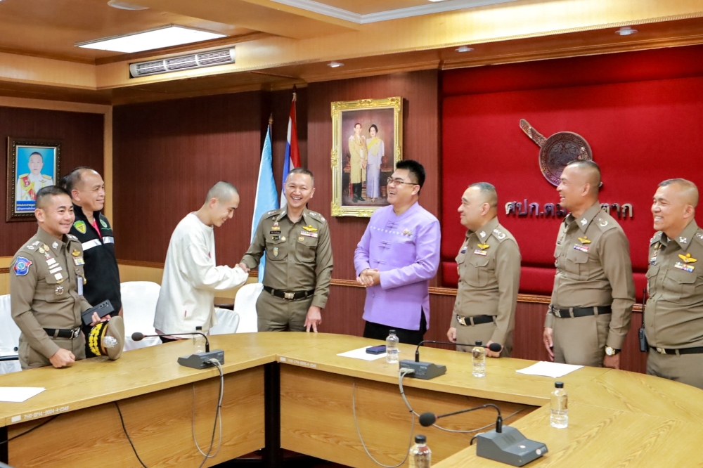 Chinese actor Wang Xing shakes hands with a Thai police officer after being assisted in his return to the country, after being kidnapped. — Reuters pic/Royal Thai Police handout