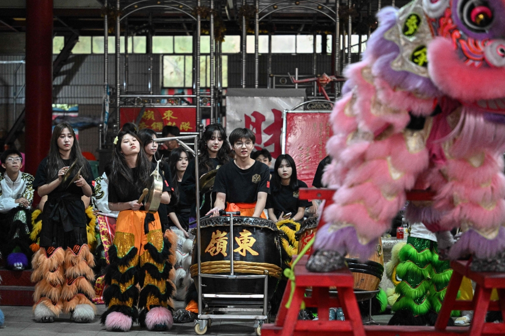 Members of a lion dance troupe playing drums and percussions during a lion dance practice session in Shantou. — AFP pic