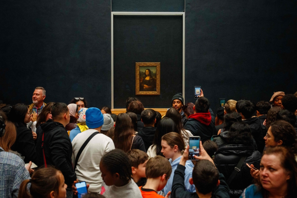 Visitors take pictures of the painting ‘La Joconde’ (the Mona Lisa) by Italian artist Leonardo Da Vinci at the Louvre museum in Paris on January 23, 2025. — AFP pic 