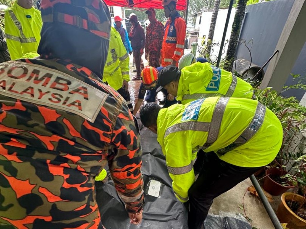 Rescuers carrying the body of one of the victims. – Picture from Sarawak Fire and Rescue Department
