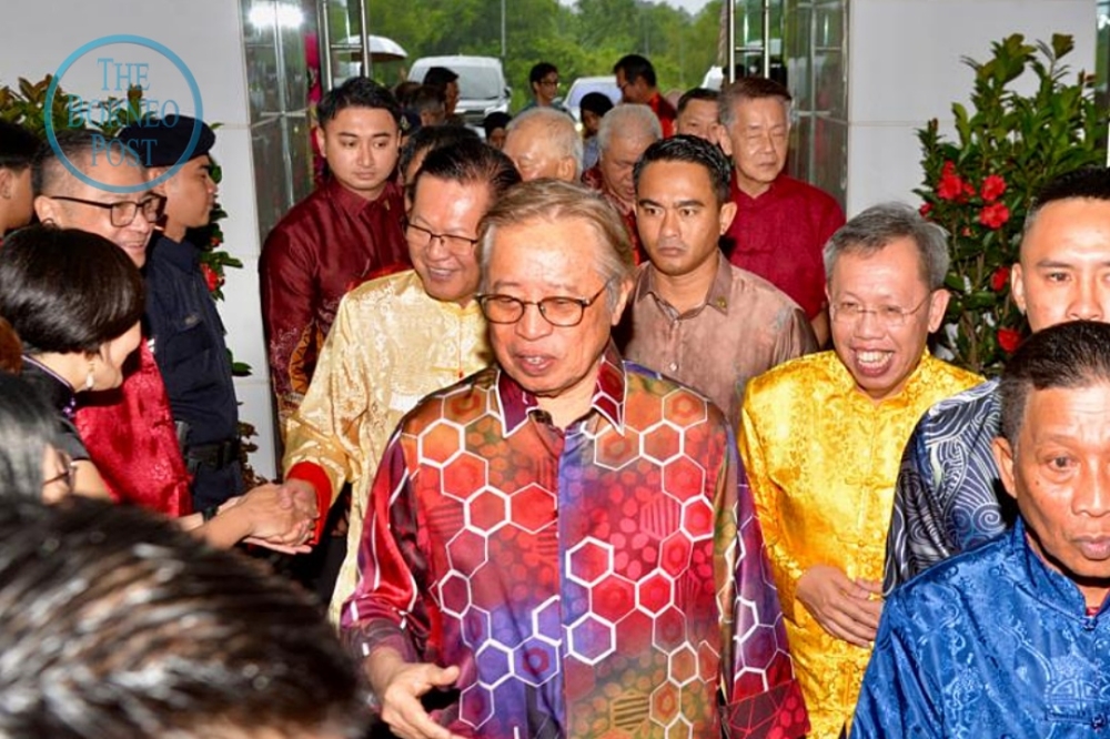 Abang Johari arrives at the State-level Chinese New Year Open House at BCCK, flanked by Dr Sim (right) and Lee (back, left). — The Borneo Post pic