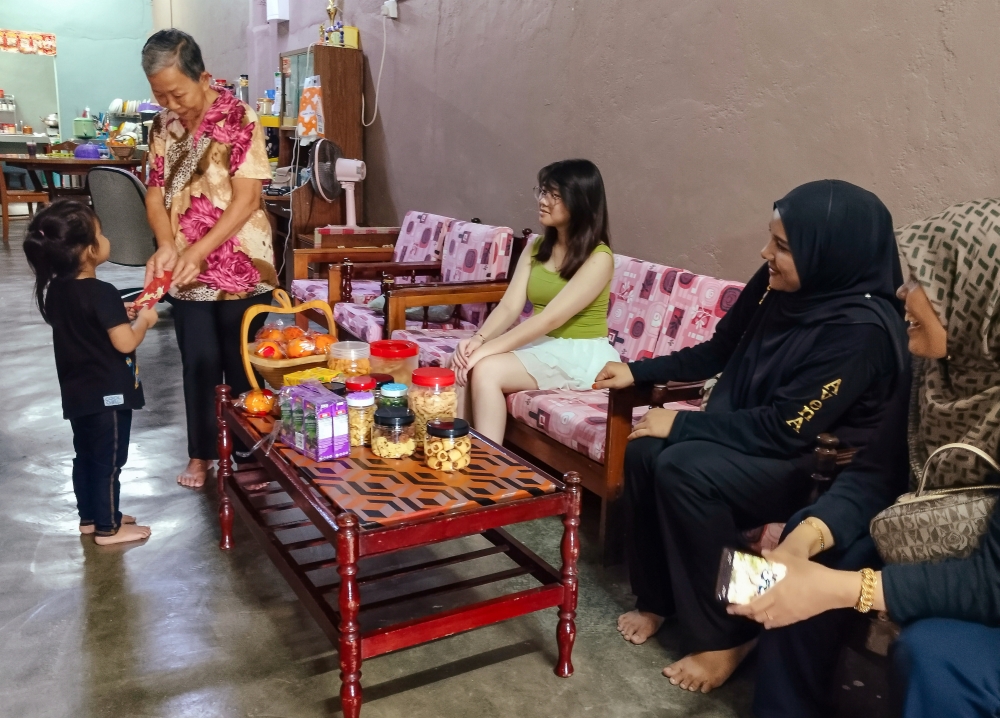 Tan Eng Wang, 75, welcomes guests visiting her home in Selising today in celebration of Chinese New Year. — Bernama pic 