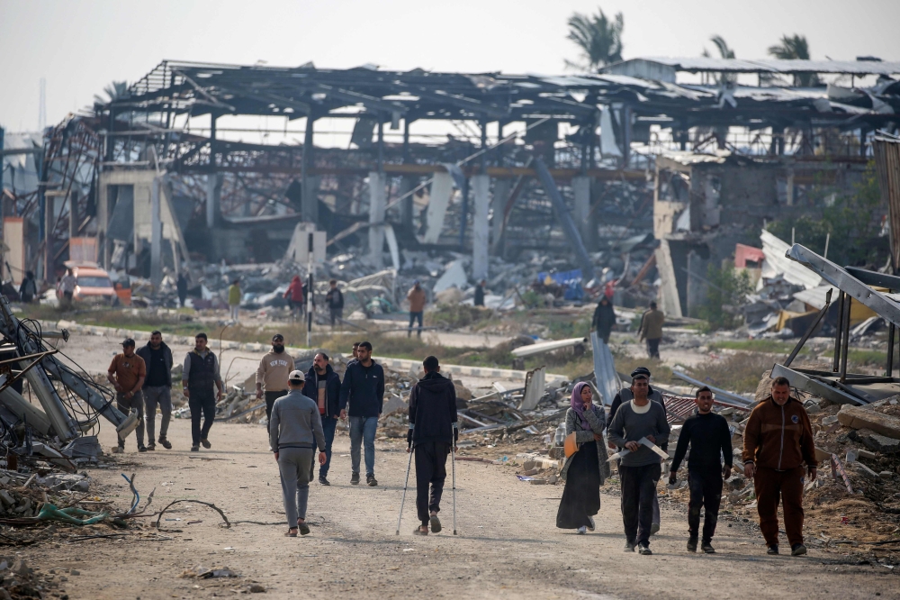 People walk along Salah al-Din road in Nuseirat as they make their way to the northern part of the Gaza strip on January 28, 2025. — AFP pic