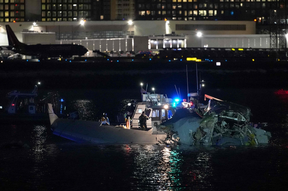 Emergency response units assessing the plane wreckage in the Potomac River. — AFP pic