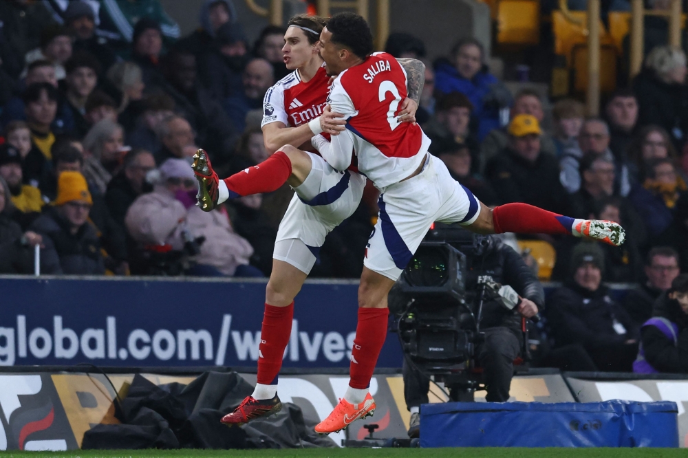Arsenal's Italian defender Riccardo Calafiori (left) celebrates with French defender William Saliba (right) after scoring their first goal during the English Premier League football match with Wolverhampton Wanderers. — AFP pic