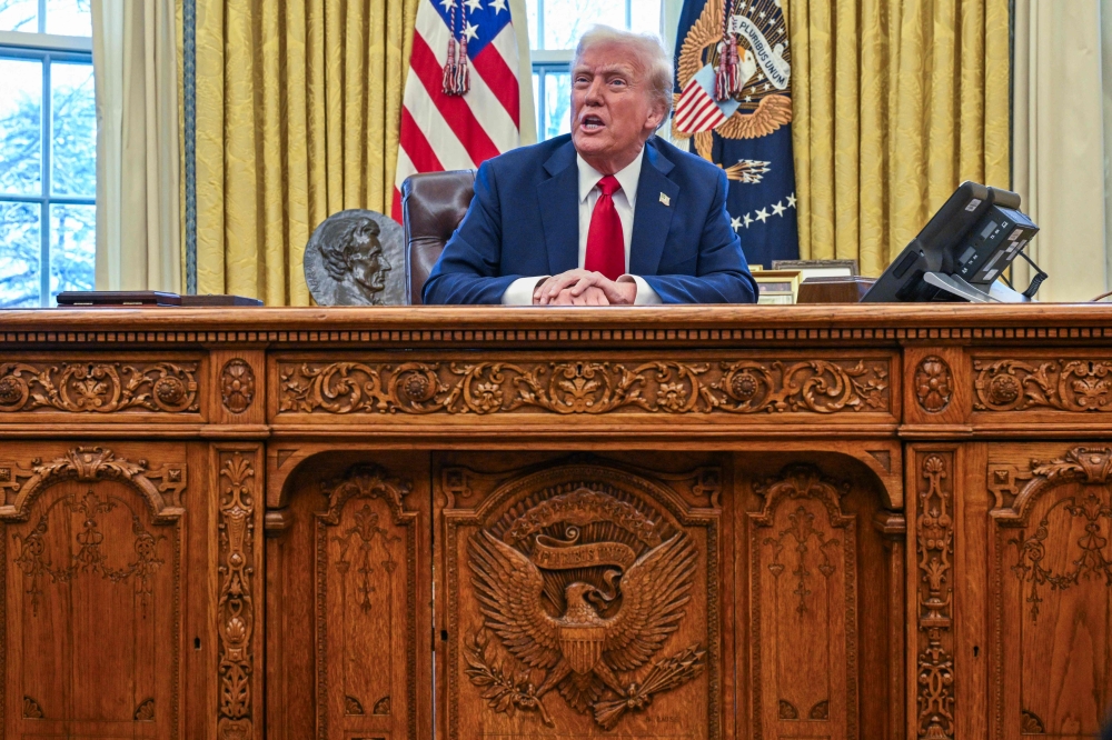US President Donald Trump speaks to the press before signing an executive order in the Oval Office of the White House in Washington, DC, on January 30, 2025. — AFP pic 