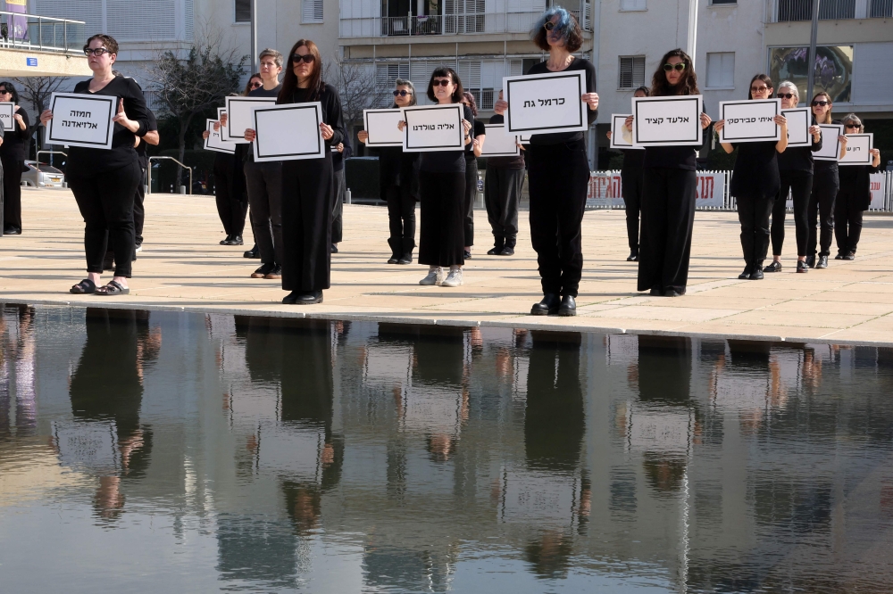 Relatives and supporters of Israelis held hostage in Gaza since Oct 7 hold the names of hostages believed to be dead, during a demonstration demanding action to rescue all kidnapped, to stop the war now and against the sabotage of the ceasefire agreement, in Tel Aviv. — Pic by AFP