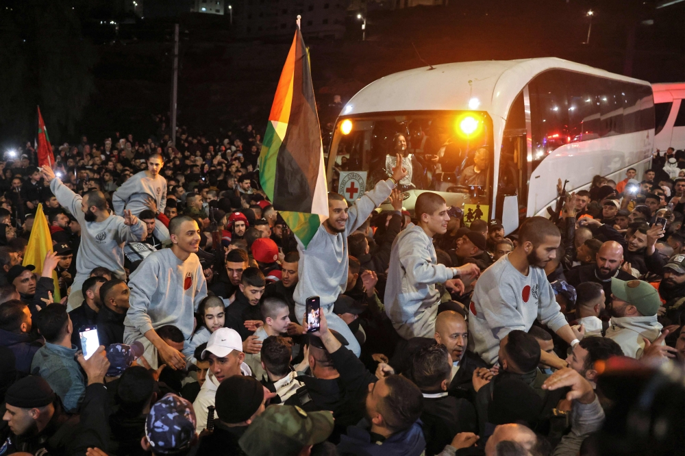 A crowd welcomes Palestinians formerly jailed by Israel as they arrive in a Red Cross convoy to Ramallah in the occupied West Bank on January 30, 2025. — AFP pic