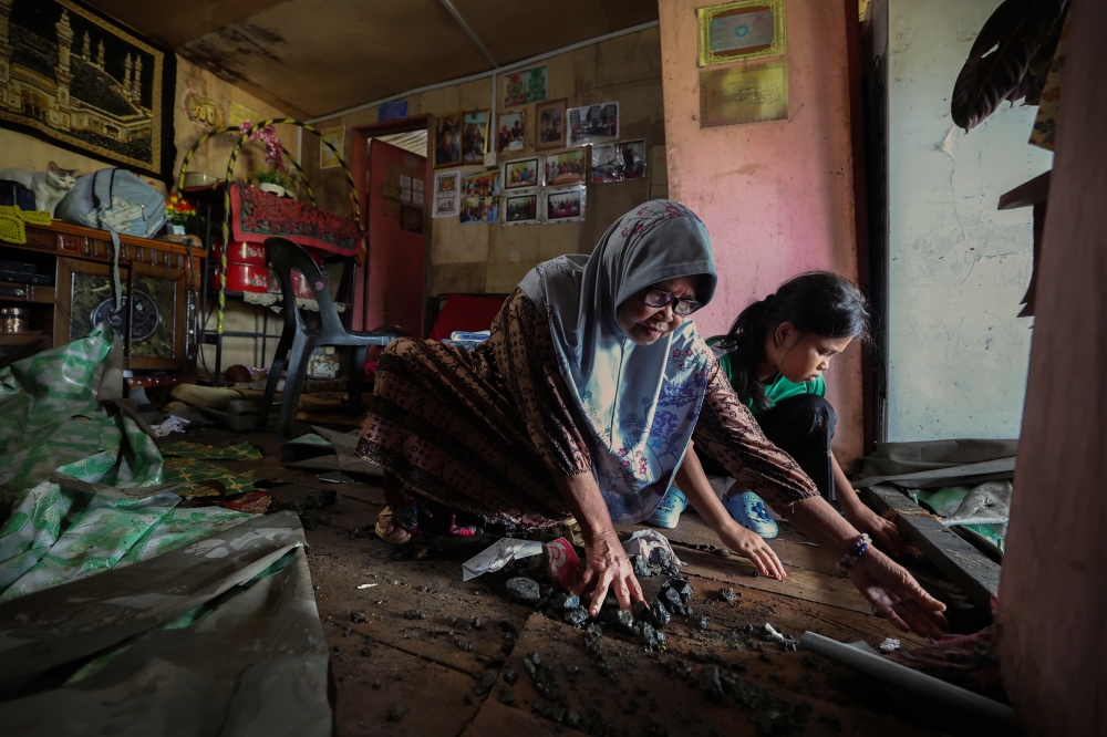 Aninah Abdullah, 73, and her granddaughter, Nur Qistina Mardiyah Rudi, 11, clean their home in Kampung Gana Jati, Telupid January 31, 2025. — Bernama pic