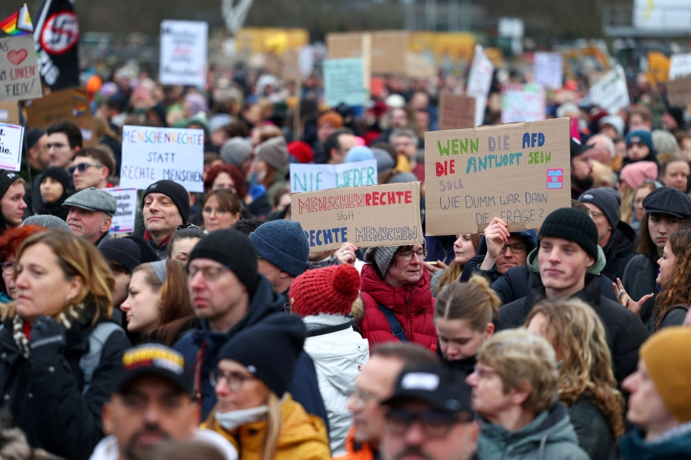 Demonstrators hold placards during a protest against the migration plans of the CDU party leader and top candidate for chancellor, Friedrich Merz and the far-right Alternative for Germany party (AfD) in Berlin, Germany February 2, 2025. — Reuters pic