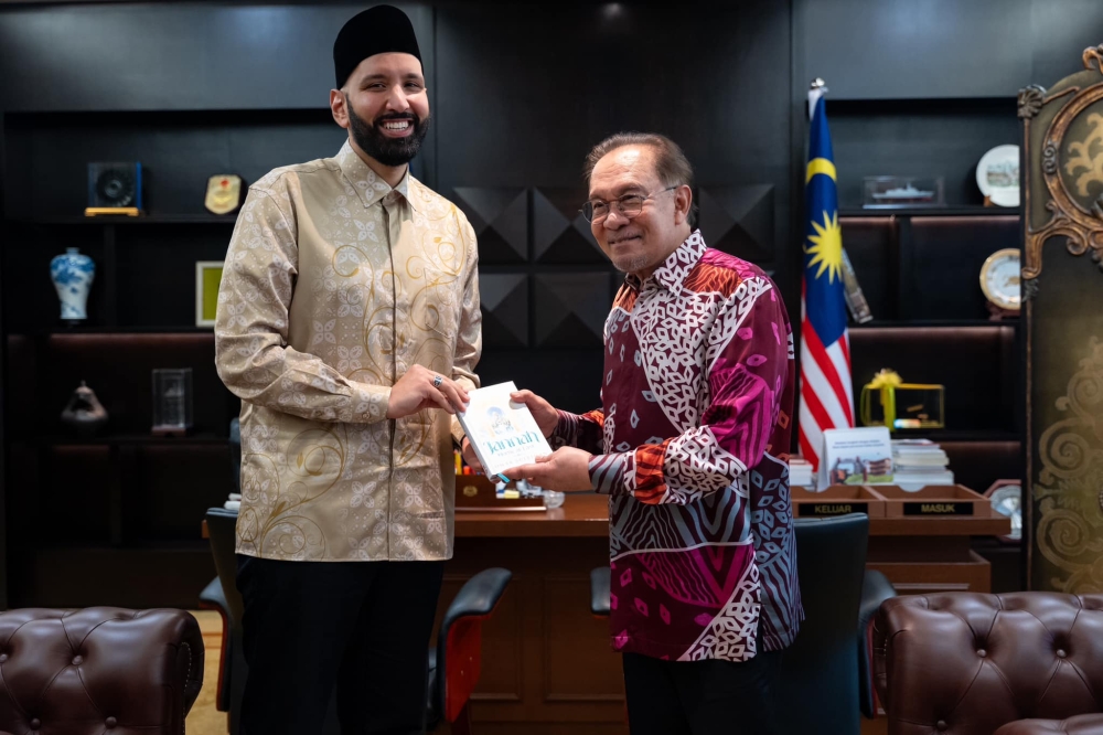 Prime Minister Datuk Seri Anwar Ibrahim receives a book from US scholar and preacher Omar Suleiman in Putrajaya February 3, 2025. — Picture via Facebook
