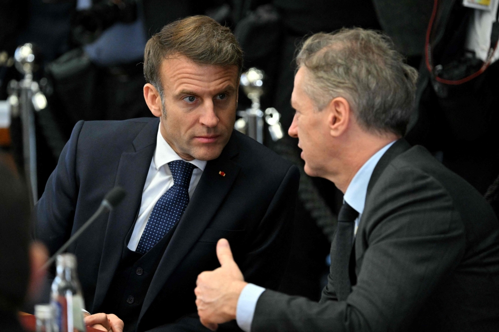 France's President Emmanuel Macron (L) speaks with Slovenia's Prime Minister Robert Golob prior to the start of the round-table meeting at the informal EU leaders. — AFP pic