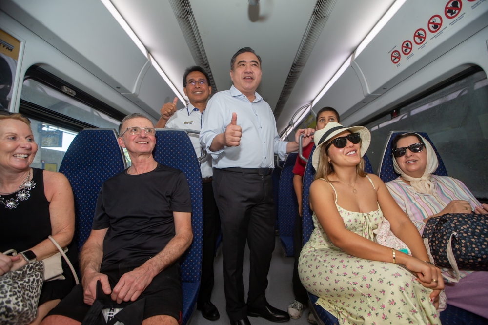 Transport Minister Anthony Loke interacts with foreign passengers onboard the KTM Komuter service during an inspection ahead of the Thaipusam 2025 celebration. February 4, 2025 — Picture By Raymond Manuel