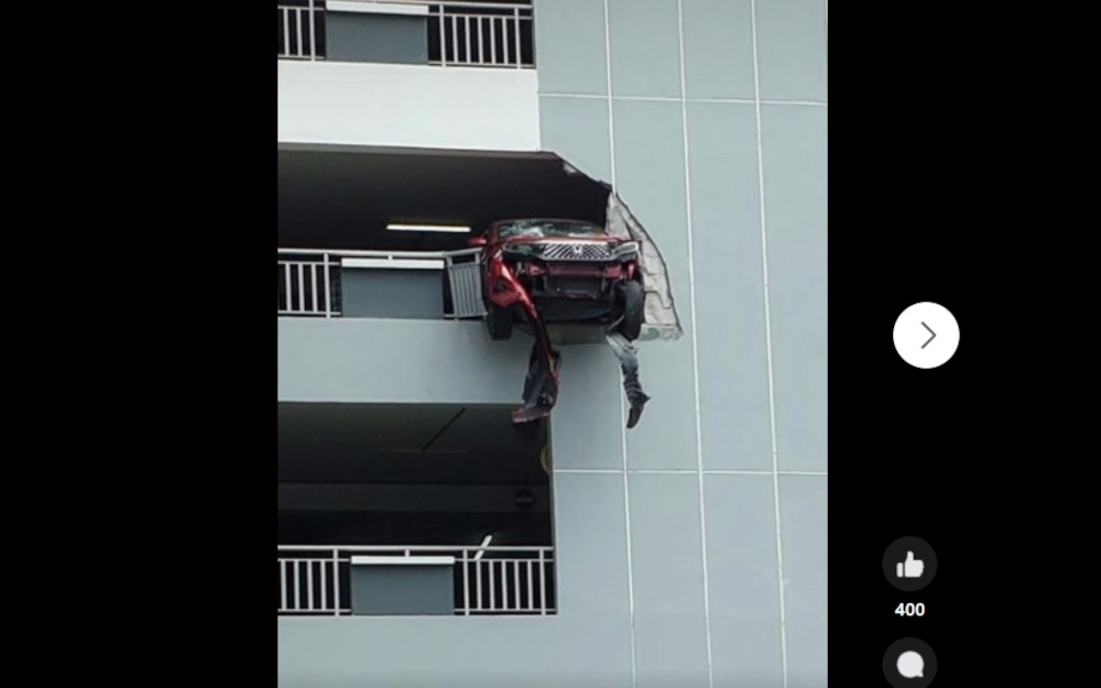 Photos and videos circulating on social media show a Honda WR-V with its front wheels and part of its body hanging over the edge of the building in this screengrab from social media. 