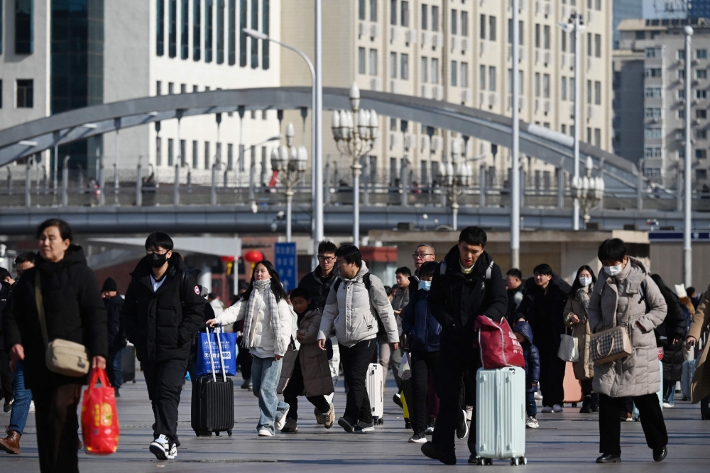 People head to a subway station after arriving at Beijing Railway Station from their hometowns after a week-long Lunar New Year national holiday on February 4, 2025. — AFP pic