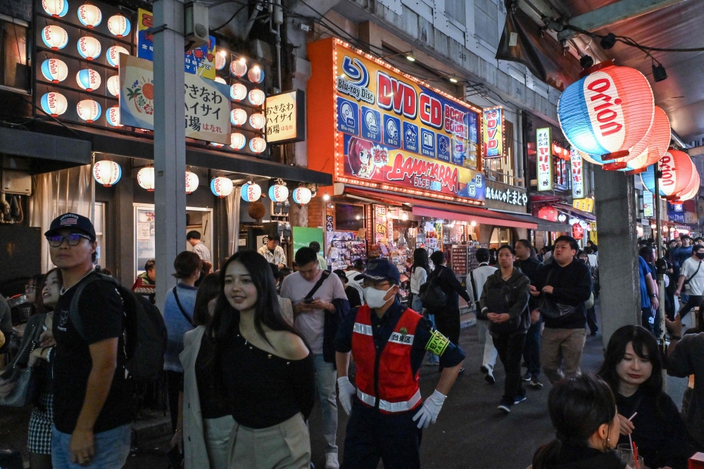 Visitors walk past restaurants in a popular tourist area next to the rail tracks in the Ueno district of central Tokyo on November 17, 2024. — AFP pic