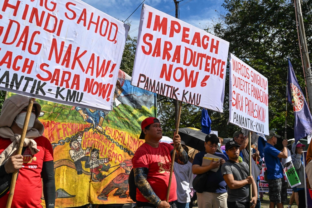 Protesters hold placards during a rally in support of the impeachment complaint against Philippines Vice President Sara Duterte in Manila on January 31, 2025. — AFP pic
