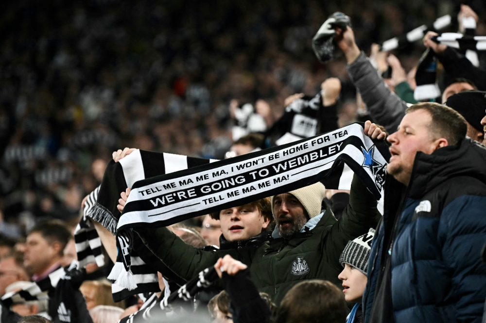 Newcastle United supporter holds a scarf reading ‘We are going to Wembley (referring to Wembley stadium where the League Cup final takes place)’ during the English League Cup semi-final second leg football match between Newcastle United and Arsenal at St James' Park, in Newcastle-upon-Tyne February 5, 2025. — AFP pic