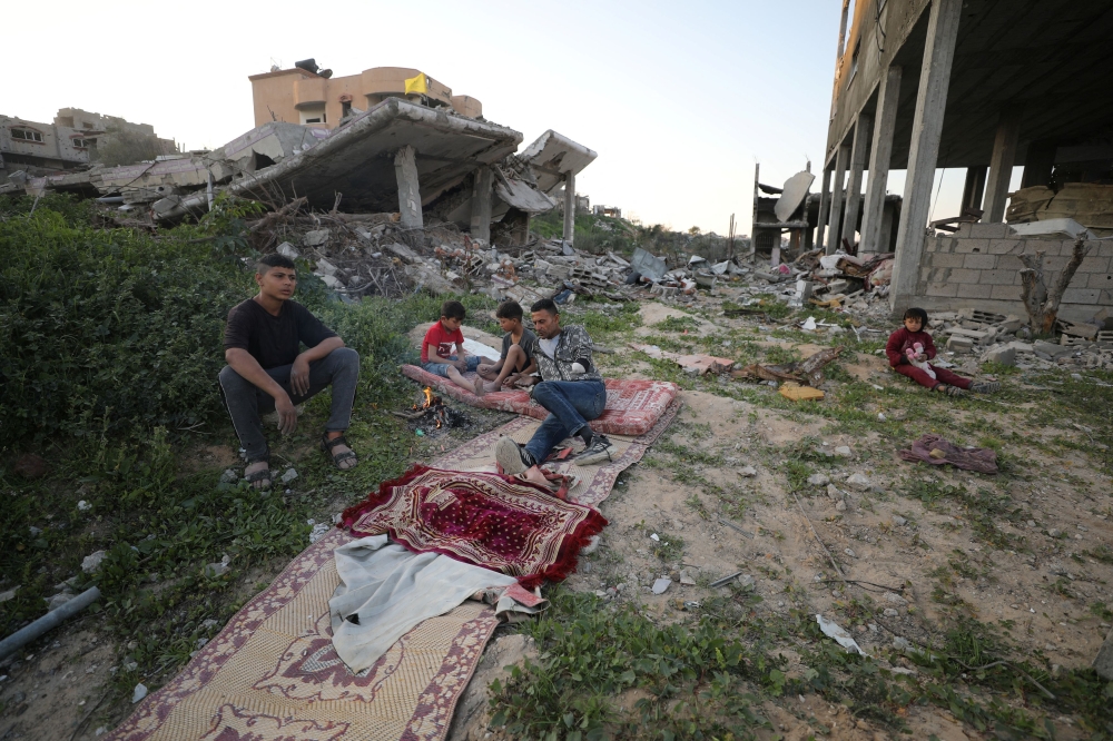 File pic of Ismael Mohammed, 47, who was displaced with his family to the southern part of Gaza at Israel's order during the war, rests with his children near the rubble of their destroyed house after returning to it amid a ceasefire between Israel and Hamas, in Jabalia, northern Gaza Strip, January 30, 2025. — Reuters pic