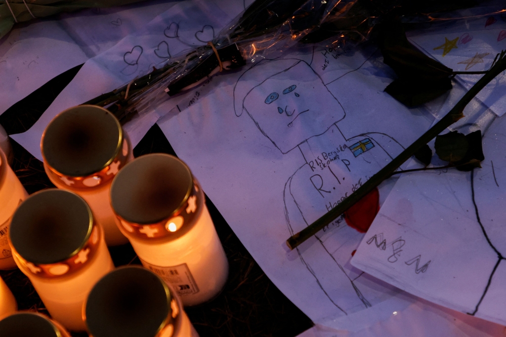 Candles, notes and flowers are placed near the Risbergska school, following a deadly shooting attack at the adult education centre, in Orebro, Sweden, February 6, 2025. — Reuters pic