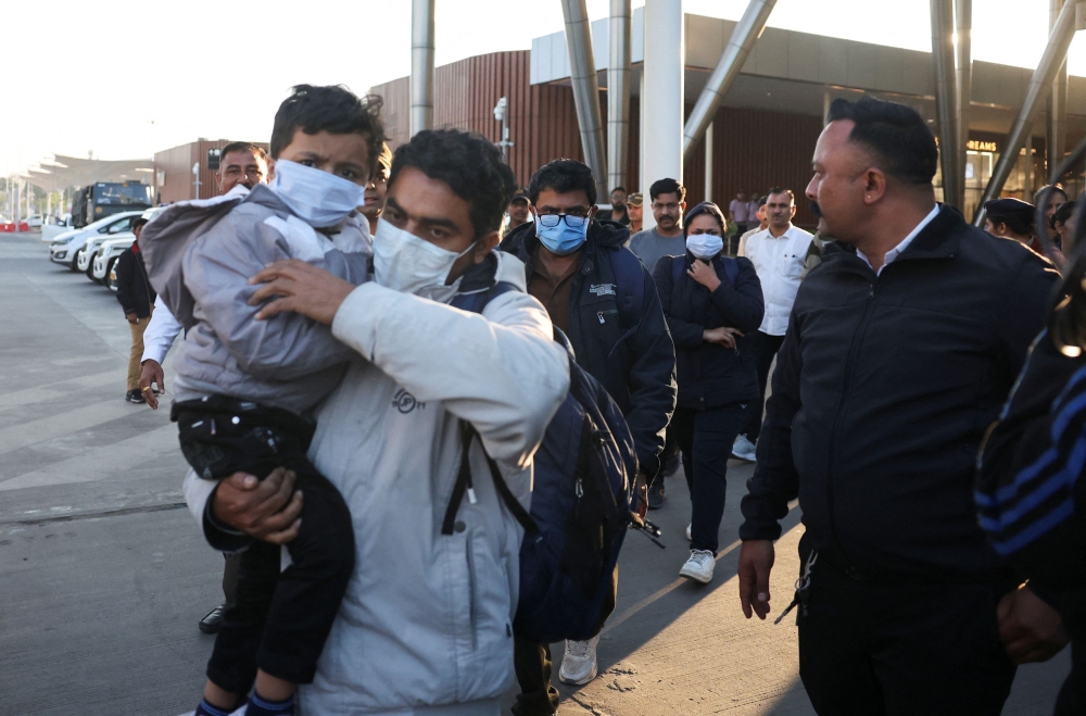 Indian immigrants deported from the US, walk out of the airport in Ahmedabad February 6, 2025. — Reuters pic