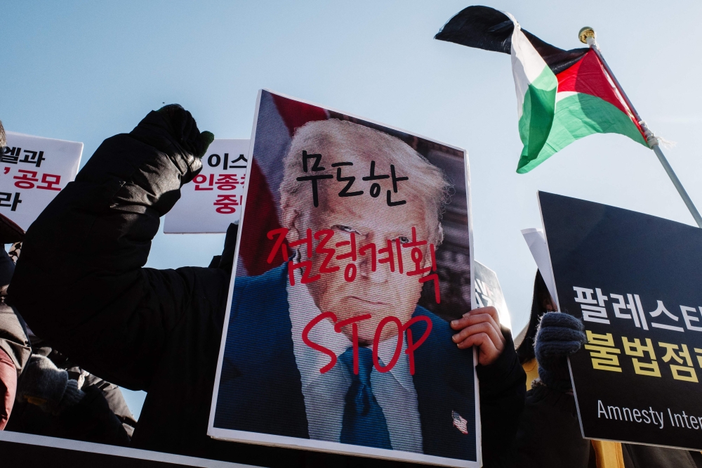 An activist holds a placard of US President Donald Trump with writing that translates as ‘Unruly Occupation Plan’ during a rally in support of Palestinians in front of the US embassy in Seoul February 6, 2025. — AFP pic