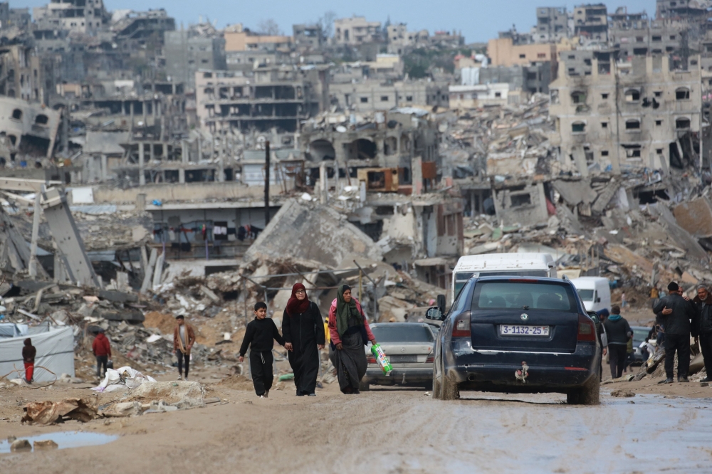 Displaced Palestinians walk through a muddy road amid the destruction in Jabalia in the northern Gaza Strip on February 6, 2025, during a truce in the war between Israel and Hamas. — File pic via AFP