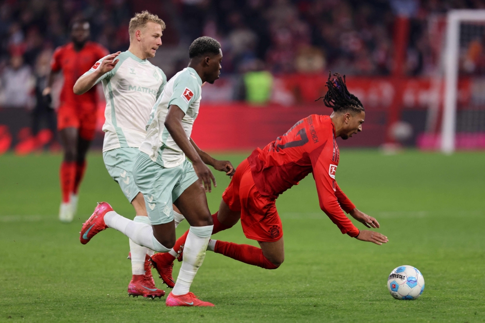 Bayern Munich’s Michael Olise (right), Bremen’s Derrick Koehn (centre) and Marco Gruell vie for the ball — Pic by AFP