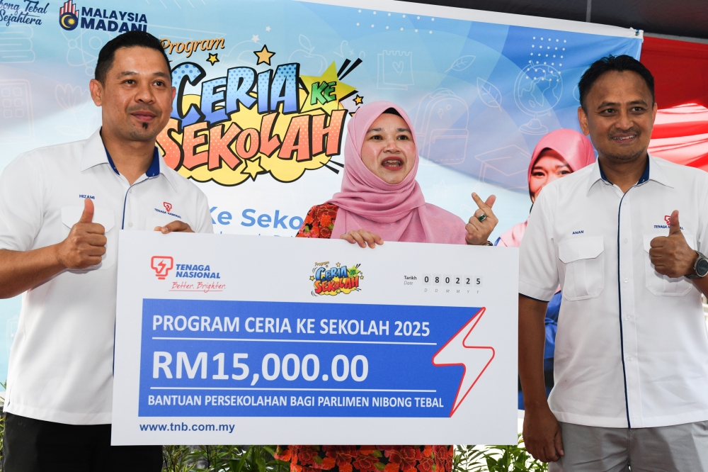 Education Minister Fadhlina Sidek (centre) receives a mock cheque worth RM15,000 for school aid in the Nibong Tebal parliamentary constituency from Penang Tenaga Nasional Berhad (TNB) General Manager, Norhizami Abu Hasan (left), during the Ceria Sekolah Programme for Nibong Tebal, organised by TNB at the Nibong Tebal Parliamentary Service Centre. — Bernama pic