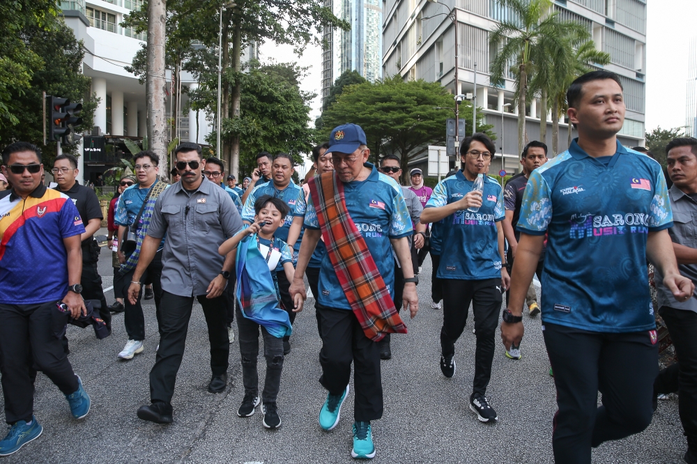 Prime Minister Datuk Seri Anwar Ibrahim walks with a kain pelikat draped over his shoulder at Malaysia Sarong Music Run 2025 in Kuala Lumpur on February 8, 2025. — Picture by Yusof Mat Isa