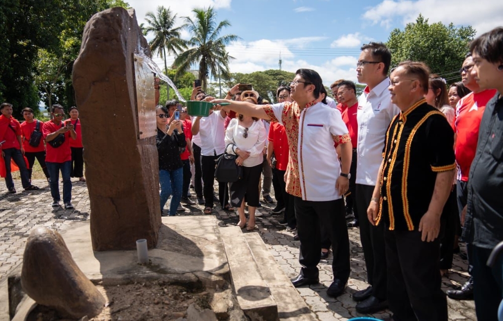 Upko president Datuk Ewon Benedick uses a dipper to splash water on to the Keningau Oath Stone on January 25, 2025. — The Borneo Post pic