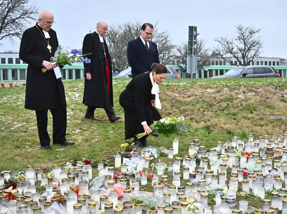 Archbishop Martin Modeus, Bishop Johan Dalman, Crown Princess Victoria and Prince Daniel of Sweden place flowers at the makeshift memorial in honor of the victims of the shooting at the adult education center Campus Risbergska school in Orebro, Sweden, on February 9, 2025. — AFP/Sweden OUT pic