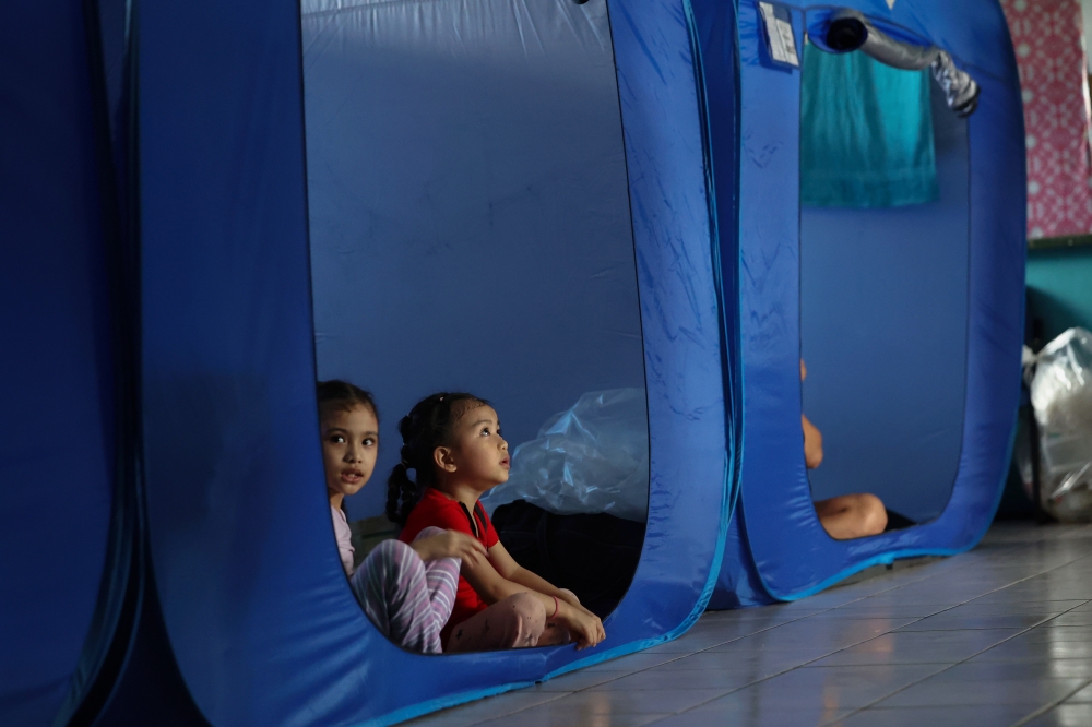 Two children sit inside a tent at the Temporary Evacuation Centre (PPS) at Sekolah Kebangsaan Sukau in Sabah after their home was flooded due to the overflow of the Kinabatangan River in this file picture dated February 4, 2025. — Bernama pic