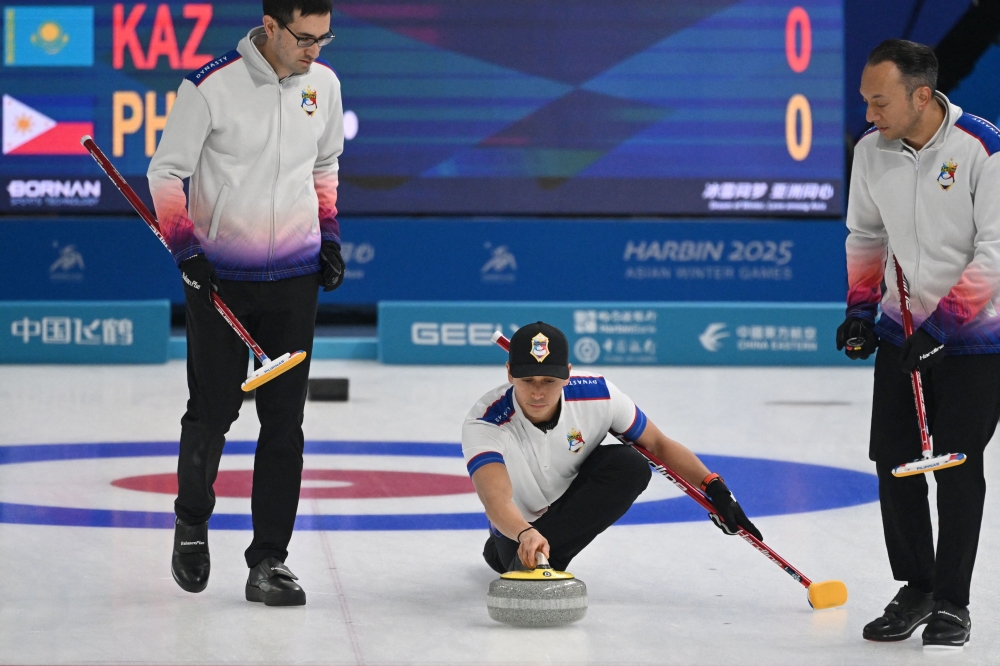 Philippines’ Enrico Pfister (centre) curls a stone during the 2025 Asian Winter Games in Harbin, China on February 10, 2025. — AFP pic