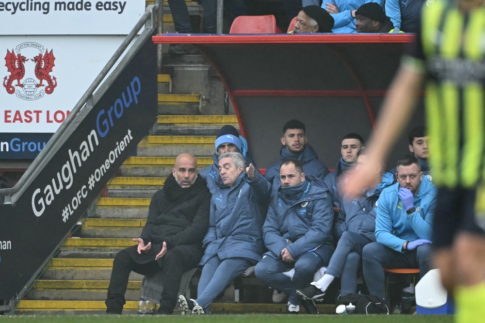 Manchester City's manager Pep Guardiola (left) and assistant coach Juan Manuel Lillo (second left) speak during the English FA Cup fourth round football match with Leyton Orient. — AFP pic