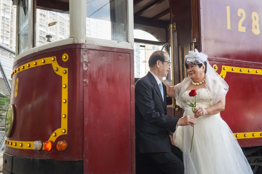 A couple pose for wedding photos on the steps of a tram in Hong Kong November 17, 2024. — AFP pic