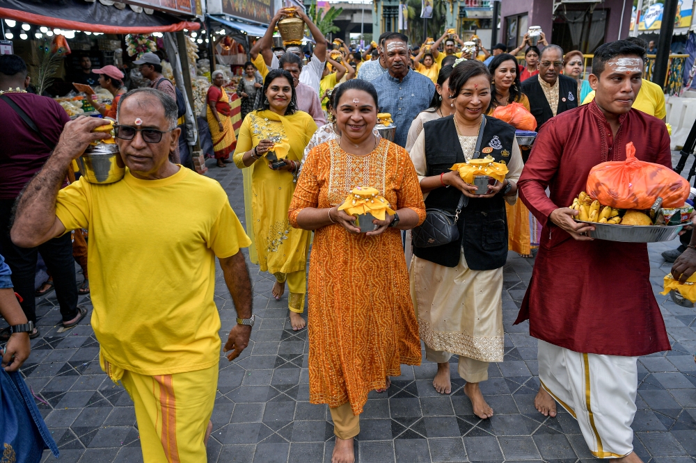 Bukit Aman Special Branch E1 assistant director SAC G. Seetha Dewi M. G. Nair (2nd left) carries a pot filled with milk during the ‘Community Policing Thaneer Panthal’ programme in conjunction with the Thaipusam celebrations at the Sri Subramaniar Swamy Temple, Batu Caves, February 10, 2025. — Bernama pic 