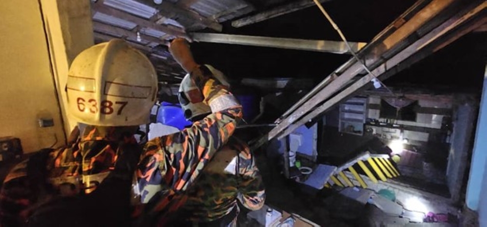 Firefighters inspect the damage to an affected kitchen at the longhouse. — The Borneo Post pic/Bomba handout