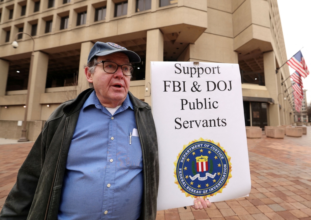 Stephen Butterfield of D.C. holds a sign outside the FBI headquarters showing his support for the FBI and Department of Justice employees, days after the Trump administration launched a sweeping round of cuts at the Justice Department, in Washington February 3, 2025. — Reuters pic  