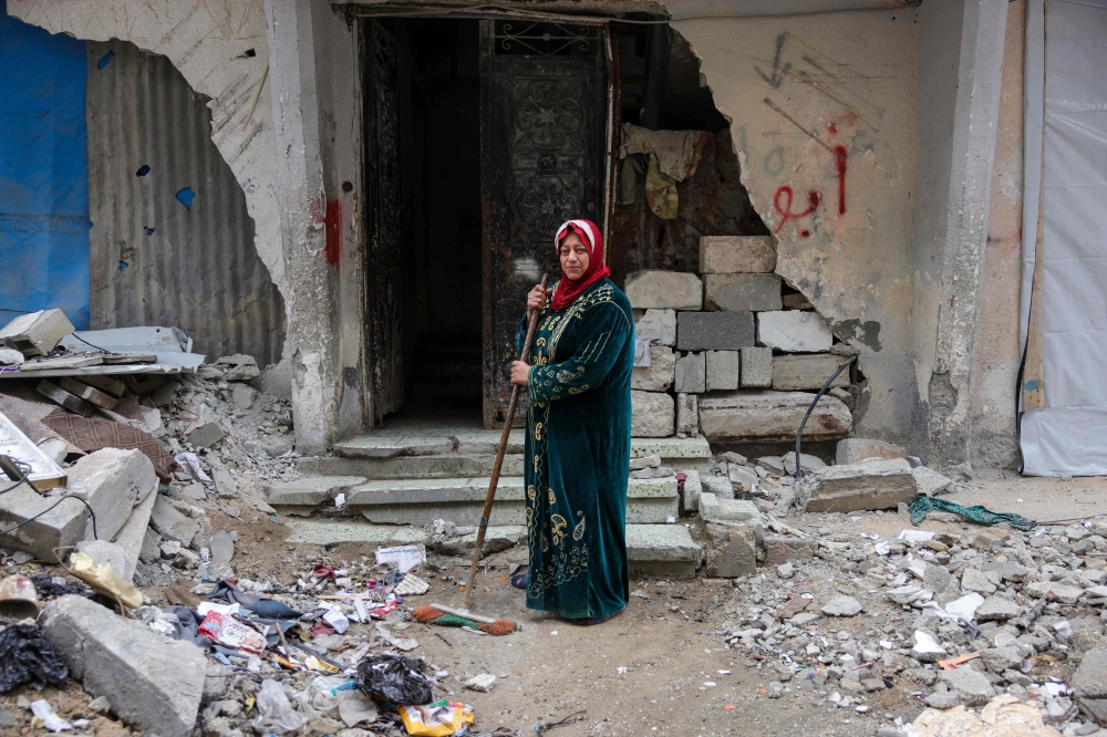 Shahira Sammour, 49, poses in front of her destroyed home in Jabalia, northern Gaza Strip, on February 9, 2025. — AFP pic