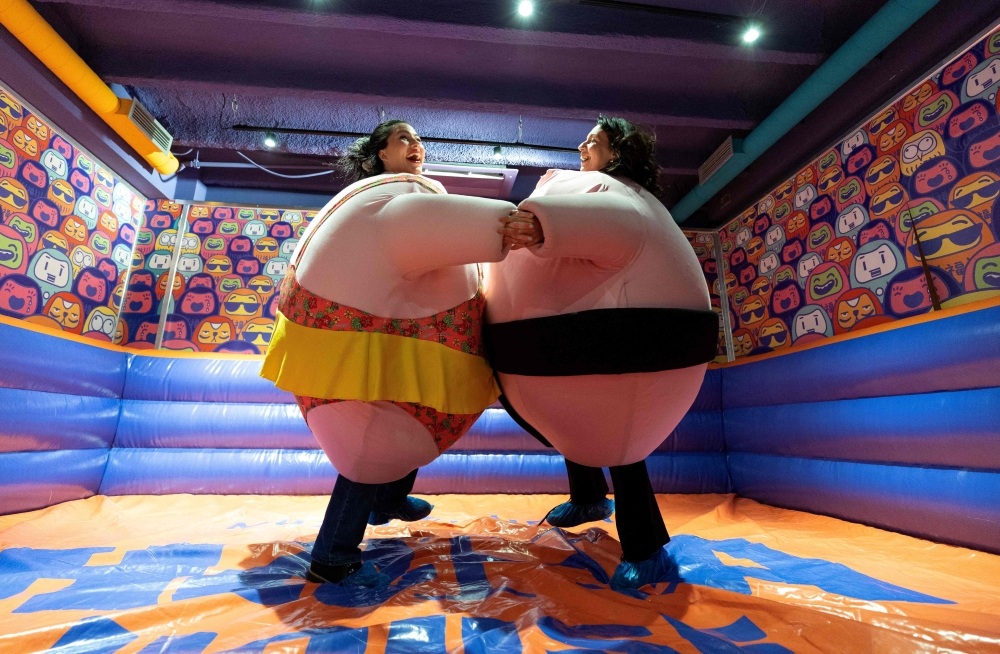 Visitors, wearing stuffed costumes, fight in the ‘sumo arena’  at the HaHaHouse museum of laughter. — Pic by AFP