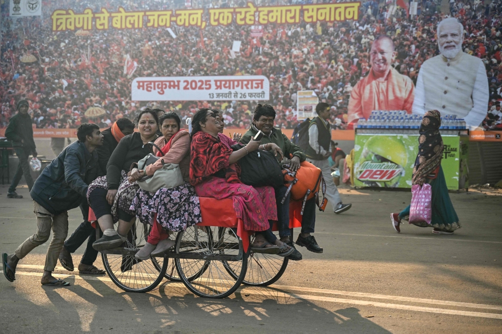 Labourers ferrying Hindu pilgrims on a hand cart during the ongoing Maha Kumbh Mela festival in Prayagraj on February 1, 2025. — AFP pic