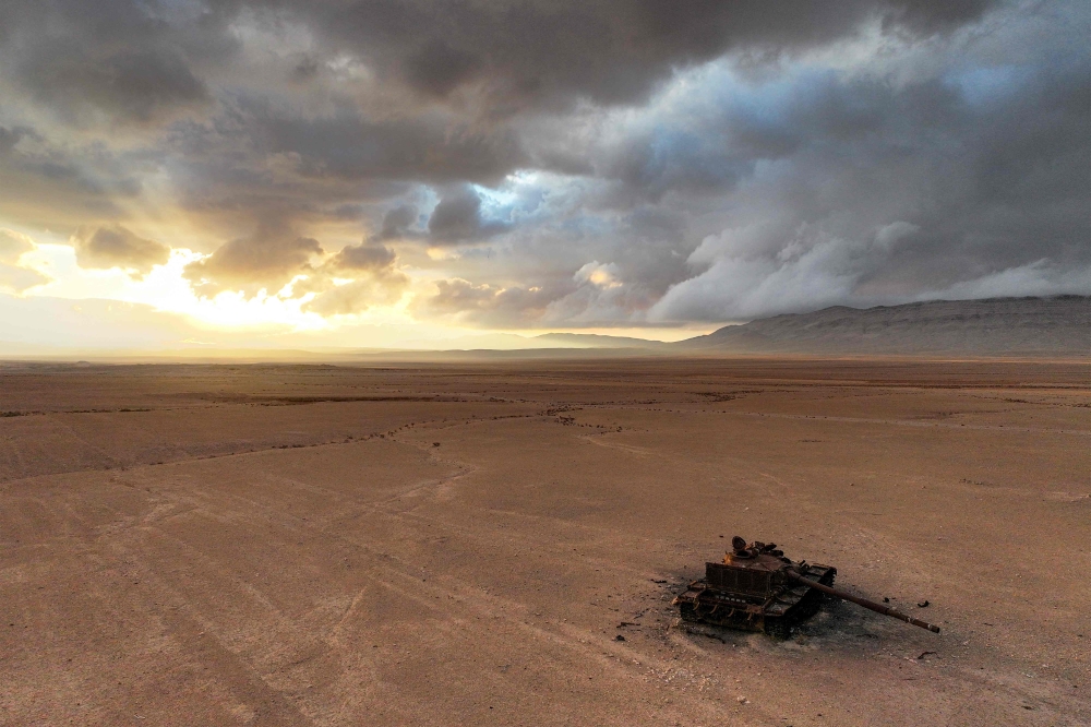 A destroyed Syrian army battle tank lies abandoned near the ancient ruins of Palmyra in central Syria on February 7. — AFP pic