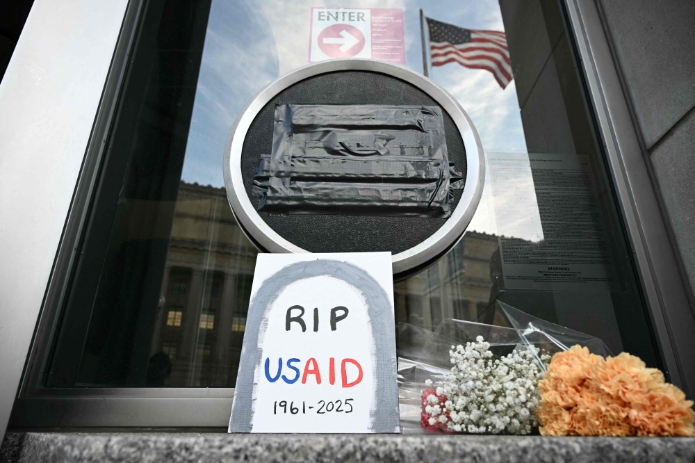 Tributes are placed beneath the covered seal of the US Agency for International Development (USAID) in Washington, DC, on February 7, 2025. — AFP pic
