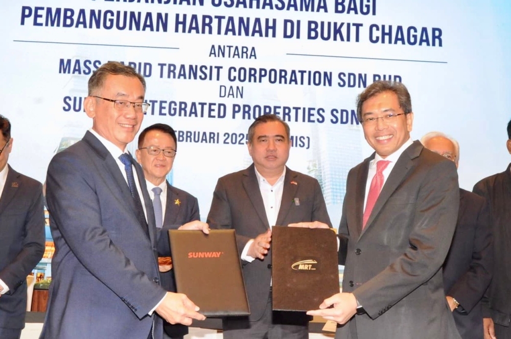 Transport Minister Anthony Loke (centre) witnesses the exchange of documents between MRT Corp CEO Datuk Mohd Zarif Hashim and Sunway Integrated Properties CEO Chong Sau Min at the signing ceremony of the Joint Venture Agreement for Property Development in Bukit Chagar between Mass Rapid Transit Corporation and Sunway Integrated Properties in Johor Baru February 13, 2025. — Picture by Ben Tan