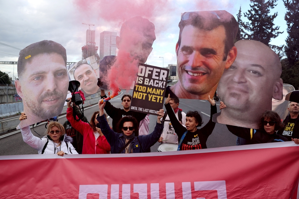 Relatives and supporters of Israeli hostages held in Gaza since the October 7, 2023 attacks, block Ayalon Highway in Tel Aviv during a protest calling for the release of all hostages today. — AFP pic