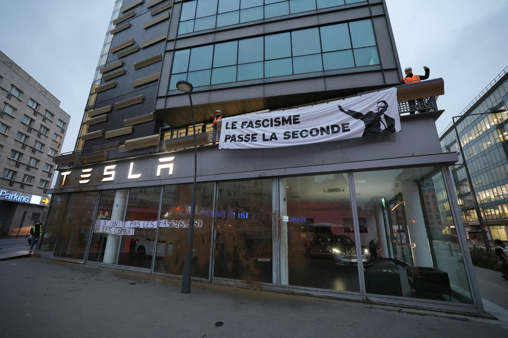 A banner reading “fascism shifts into second gear” on the facade of US car maker Tesla's headquarters in France, on February 11, 2025. — AFP pic