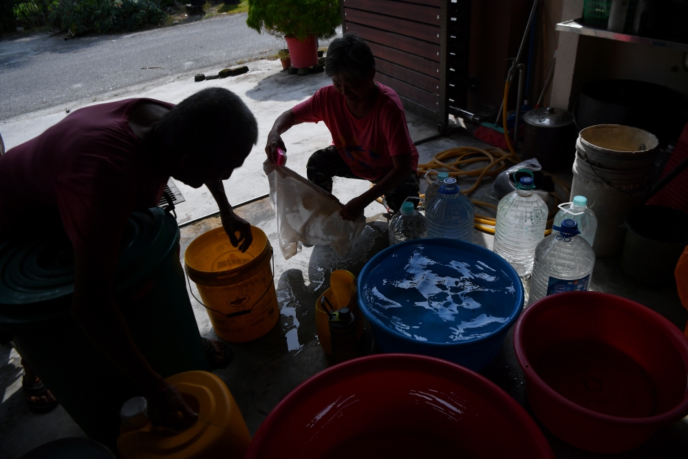 Ngo Lik Wong and his wife Kiew Siew Ying wash clothes using clean water collected in Taman Langkap, Teluk Intan February 13, 2025. — Bernama pic